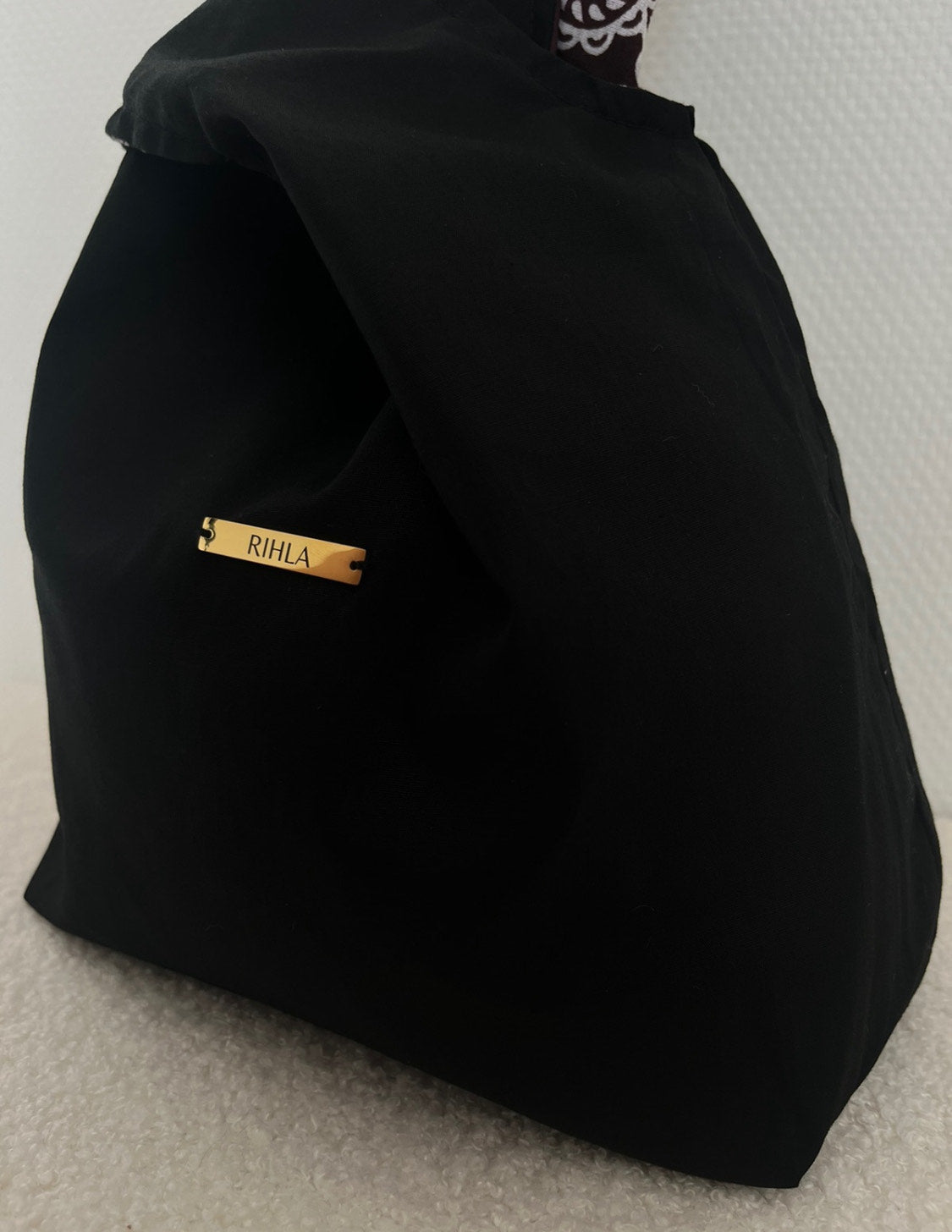 Sac réversible RIHLA en coton noir et tissu comorien marron porté à la main – mode éthique et artisanale made in France
