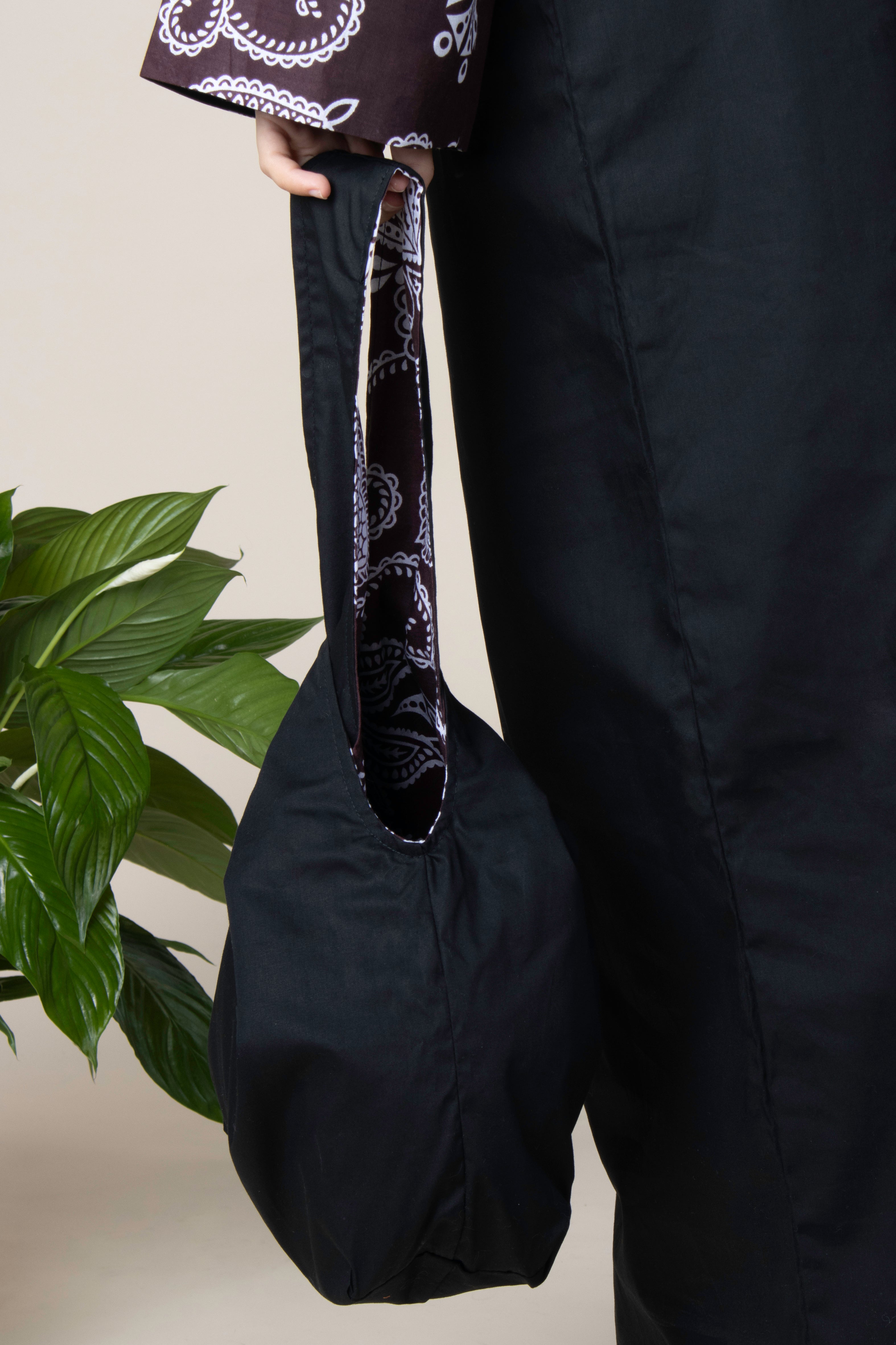 Sac réversible RIHLA en coton noir et tissu comorien marron porté à la main – mode éthique et artisanale made in France