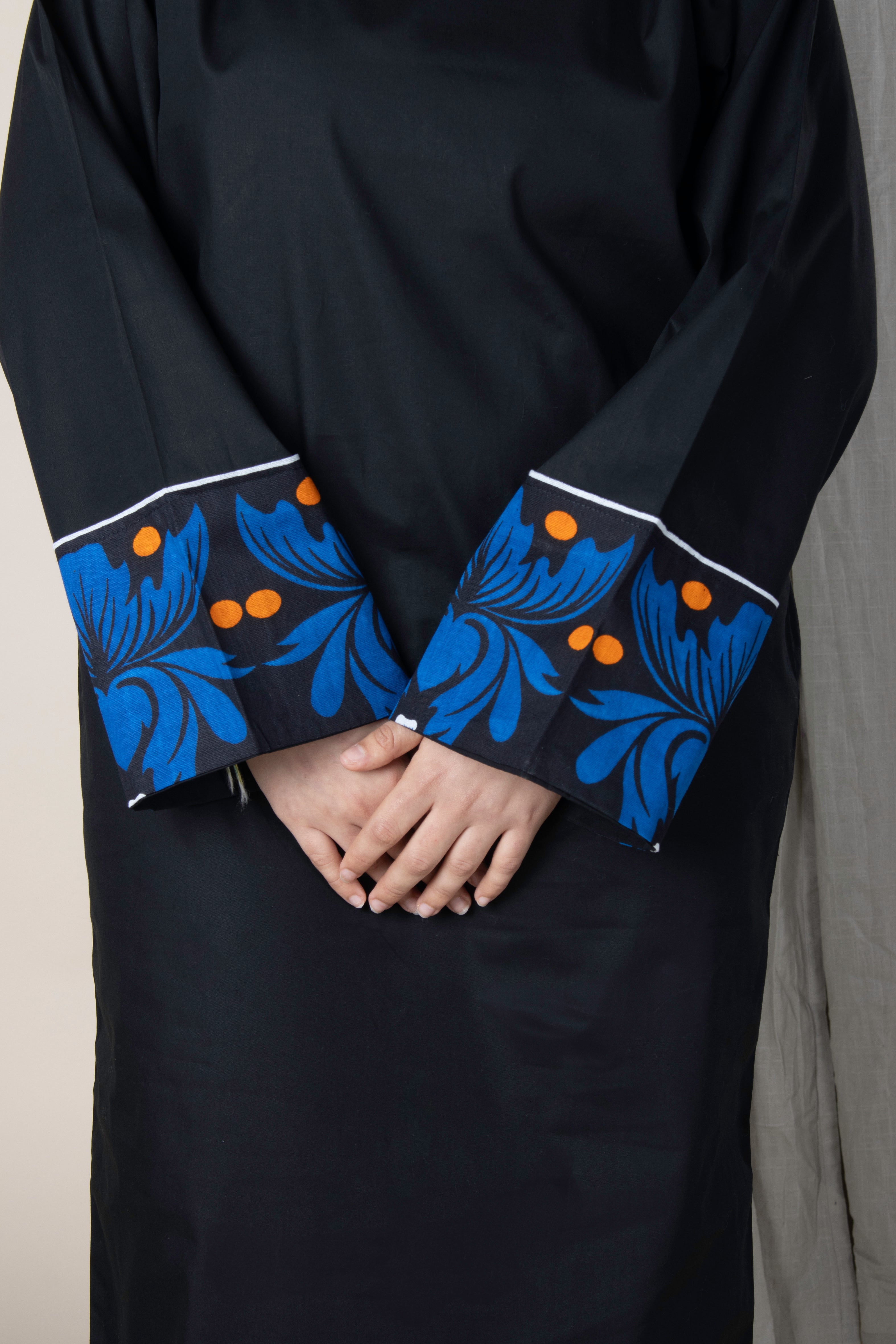 Robe noire en coton Iconi II avec poignets en tissu comorien fleuri bleu