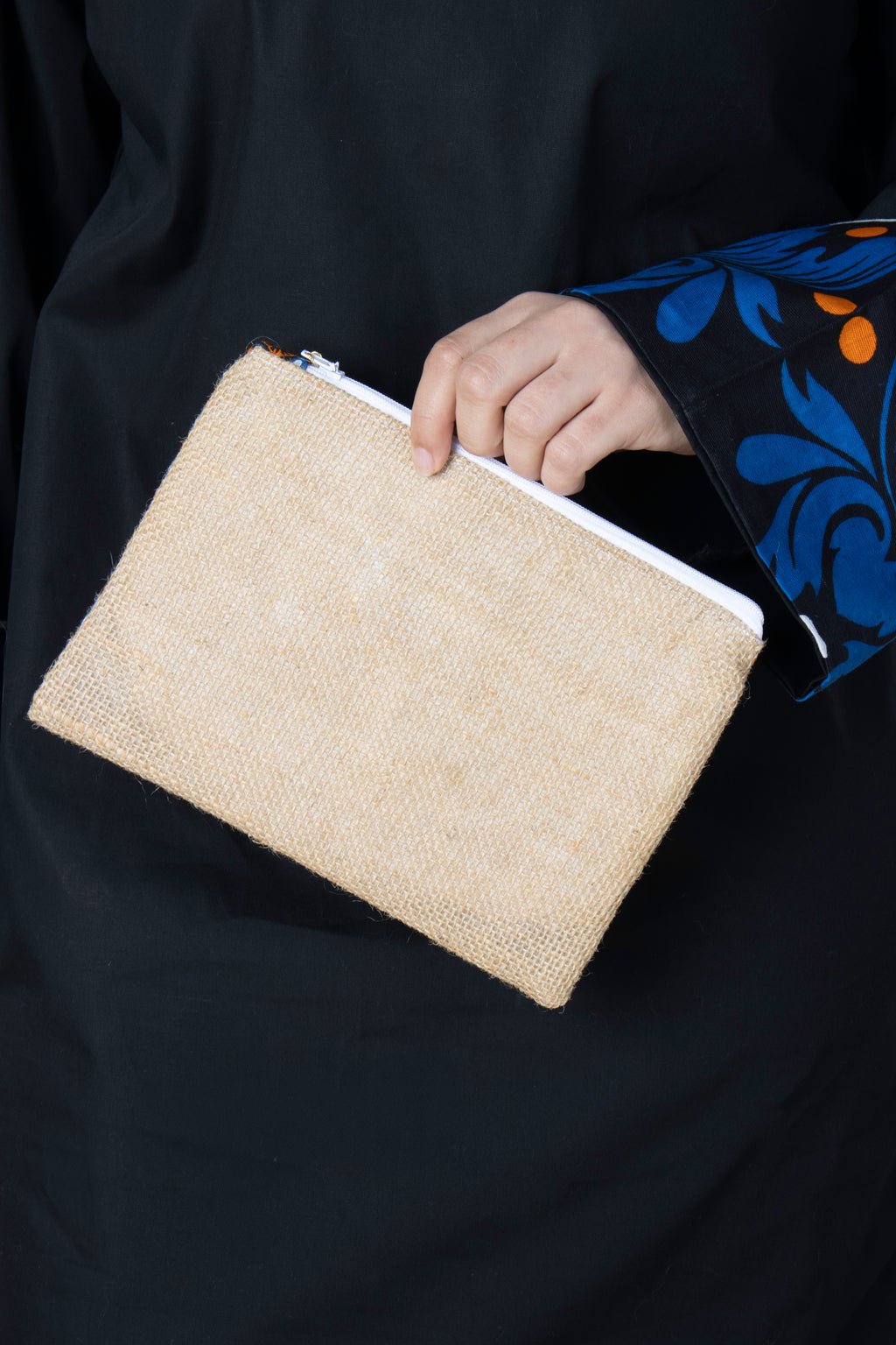 Pochette Rihla Pocket en jute et tissu comorien, accessoire artisanal coloré, modèle unique avec pompon, inspiration traditionnelle des Comores.