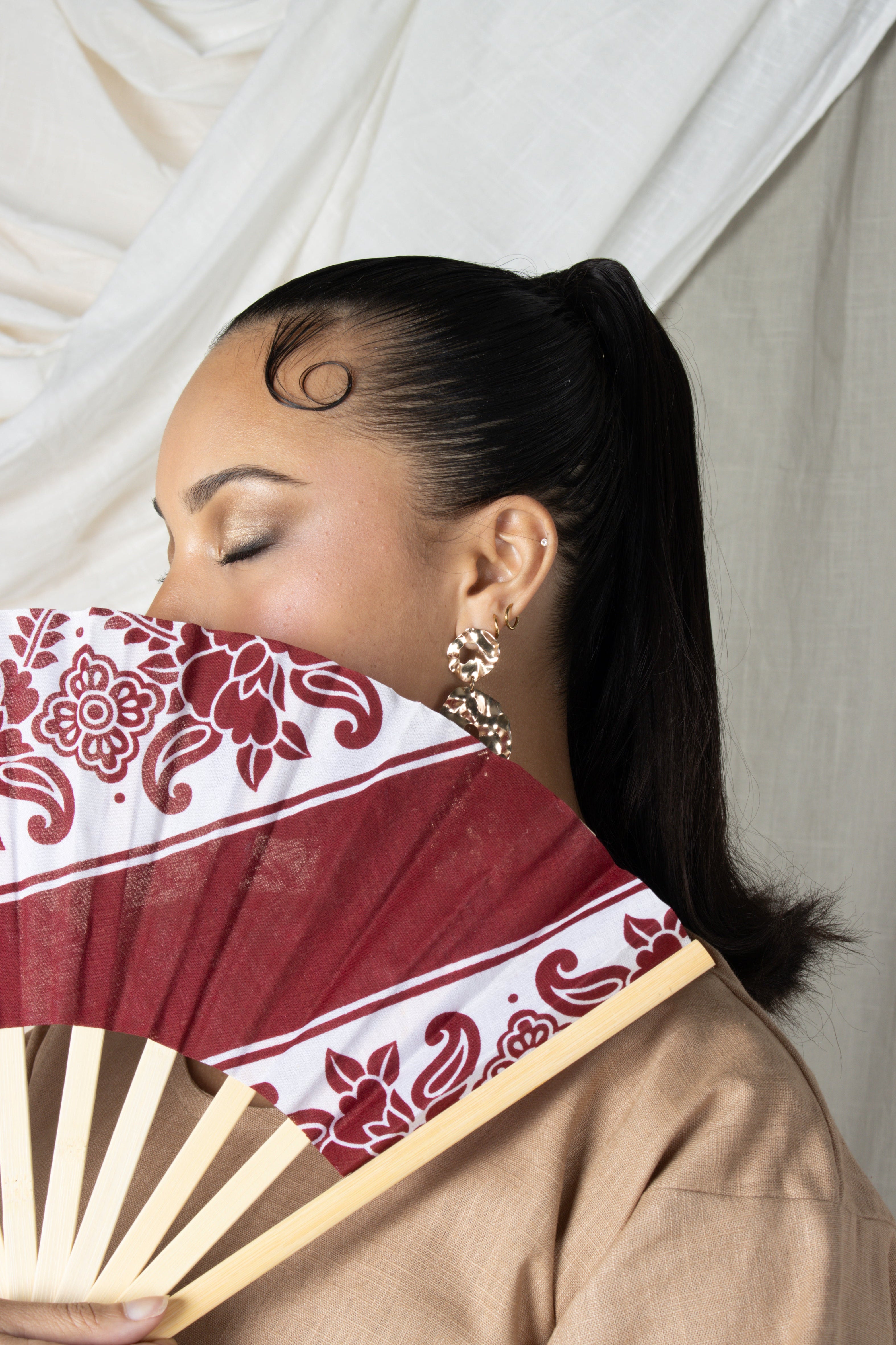 Éventail artisanal en bambou avec tissu comorien rigide coloré, fabrication française, accessoire d'été élégant et traditionnel.