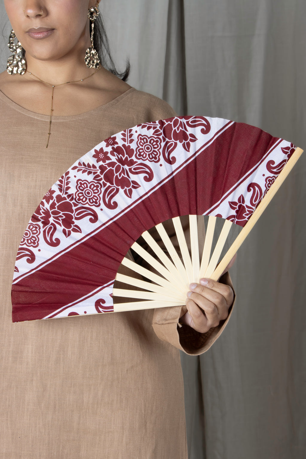 Éventail artisanal en bambou avec tissu comorien rigide coloré, fabrication française, accessoire d'été élégant et traditionnel.