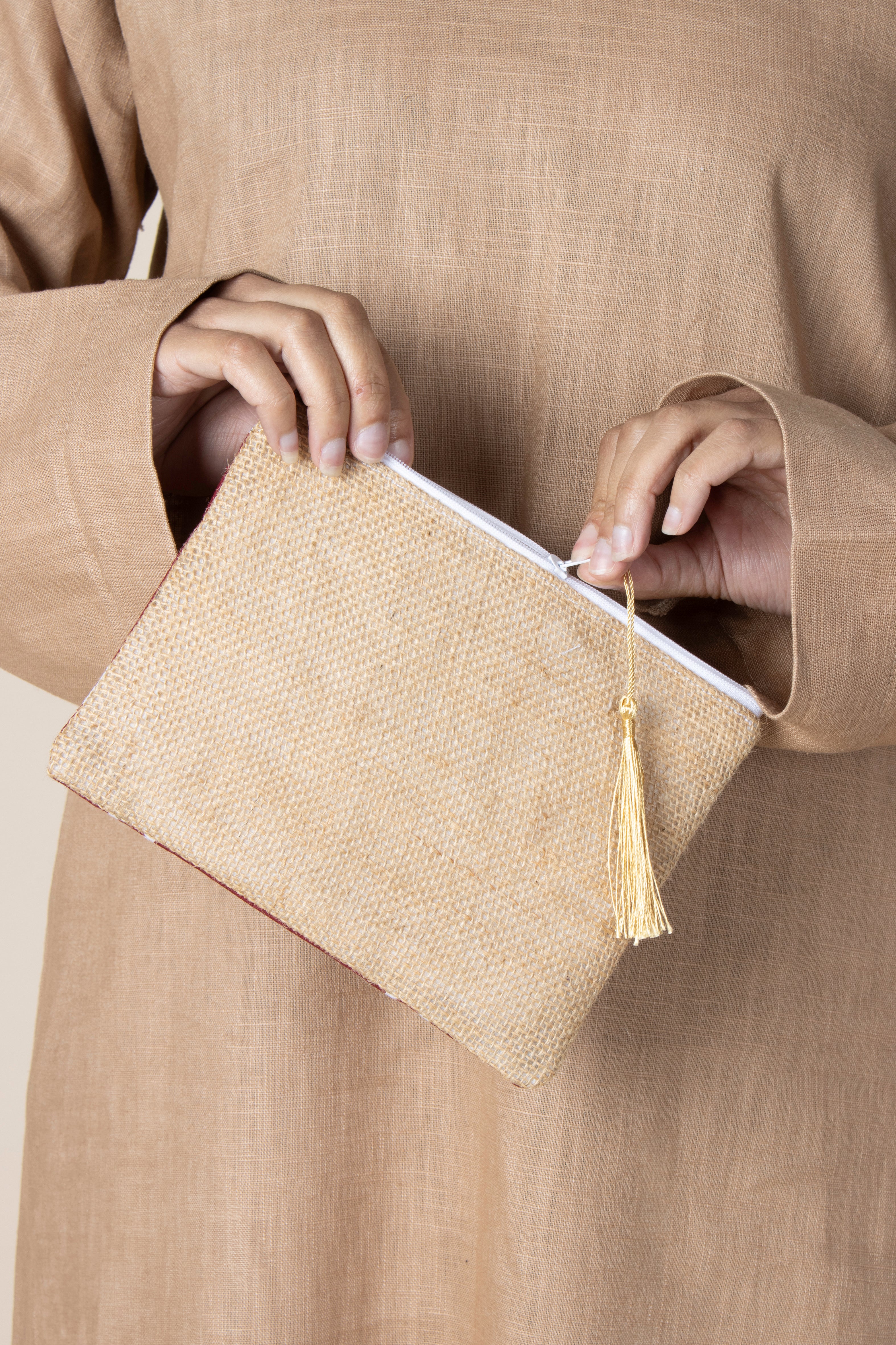 Pochette Rihla Pocket en jute et tissu comorien, accessoire artisanal coloré, modèle unique avec pompon, inspiration traditionnelle des Comores.