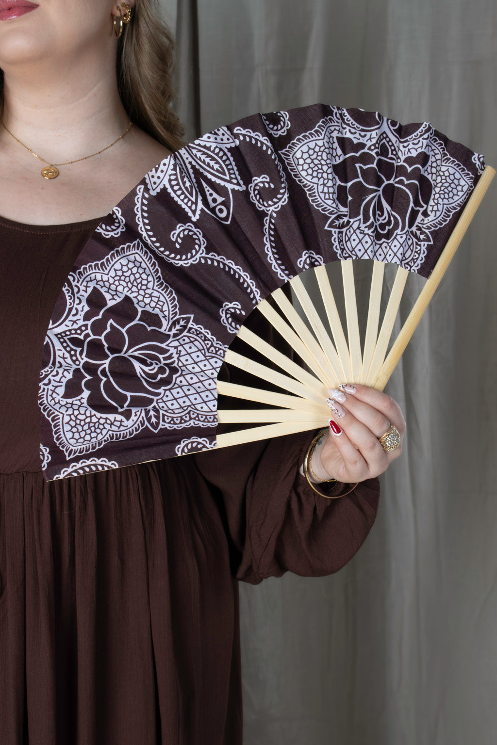 Éventail artisanal en bambou avec tissu comorien rigide coloré, fabrication française, accessoire d'été élégant et traditionnel.